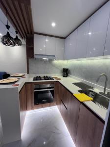 a kitchen with wooden cabinets and a stove top oven at El lujo y la comodidad in Zipaquirá