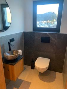 a bathroom with a toilet and a sink and a window at Ferienwohnung Heiterwang in Heiterwang +40 photos