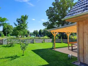 a park with a bench and a dog standing in the grass at Haus am Seeufer mit Badestelle in 200m, große Sonnenterrasse, umzäunter Garten, Hunde willkommen in Rheinsberg +46 photos