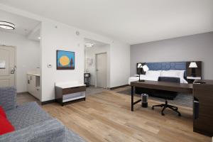 a bedroom with a bed and a desk and a couch at Hampton Inn & Suites McAllen in McAllen