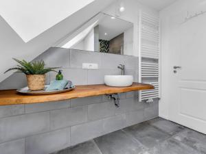 a bathroom with a sink on a wooden counter at Haus am Seeufer mit Badestelle in 200m, große Sonnenterrasse, umzäunter Garten, Hunde willkommen in Rheinsberg