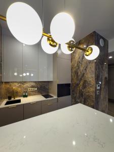 a kitchen with a white counter top and two lights at VIDOK Apartament Olsztyn Premium 204 in Olsztyn