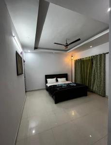 a bedroom with a black bed and a ceiling at The Retreat Base in Rājpur +7 photos