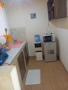 a small kitchen with a counter and a microwave at Nest Apartment Diani in Diani Beach +4 photos