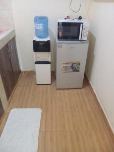 a kitchen with a microwave and a refrigerator at Nest Apartment Diani in Diani Beach
