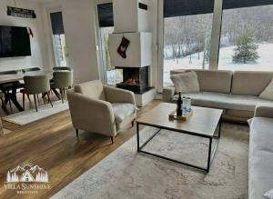a living room with a couch and a fireplace at Villa Sunshine Brezovicë in Brezovica
