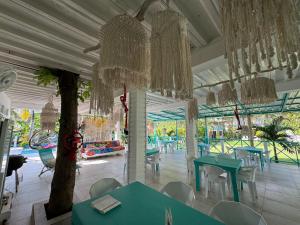 a room with tables and chairs and chandeliers at Siloe Cove Hospedaje Campestre in San Andrés