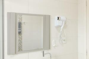 a bathroom with a mirror and a hair dryer on the wall at Casa Aconchego da Bisa - perto do Estádio do Operário! in Ponta Grossa +54 photos