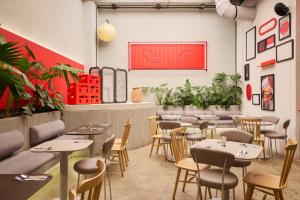 a restaurant with tables and chairs and plants at Hunters Hotel Medellin in Medellín