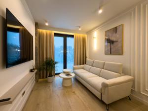 a living room with a couch and some windows at VIDOK Apartament Olsztyn Premium 204 in Olsztyn