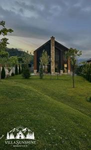 a large house in a field with a grass yard at Villa Sunshine Brezovicë in Brezovica