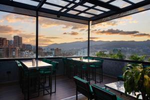 a restaurant with tables and chairs and a view of the city at Hunters Hotel Medellin in Medellín