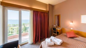 een hotelkamer met een bed en een groot raam bij Queen Olga Hotel in Thessaloniki