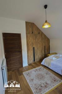 a bedroom with a bed and a wooden door at Villa Sunshine Brezovicë in Brezovica