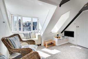 a attic living room with two chairs and a tv at 1 Bed in St. Ives oc-cp5 in St Ives