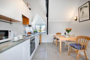 a kitchen with white cabinets and a wooden table at 1 Bed in St. Ives oc-cp5 in St Ives +7 photos