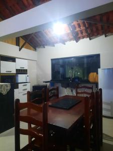 a kitchen with a table and chairs and a refrigerator at Casa - 1 Suíte e 2 Quartos in Saquarema