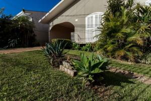 a house with a yard with plants in front of it at Casa Aconchego da Bisa - perto do Estádio do Operário! in Ponta Grossa