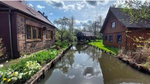 a river in front of two buildings next to a building at Spreewald Błota Jéwa Ferienwohnung mit Terrasse und Parkplatz in Lübbenau