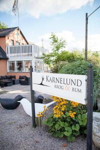 a sign in front of a building with some furniture at Karnelund Krog & Rum in Simrishamn