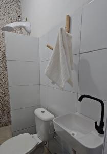 a white bathroom with a toilet and a sink at Casa Corrupião - Ilha do Ferro - Alagoas in Pão de Açúcar