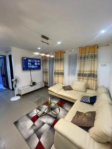 a living room with two couches and a flat screen tv at Studio Meublé Bonamoussadi 4è in Bonamoussadi