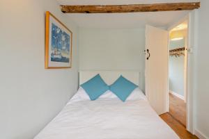 a bedroom with a white bed with blue pillows at 2 Bed in Walberswick oc-h29096 in Walberswick