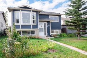 a house with blue paint and a yard at Spacious 2-Bedroom Basement Suite in Whitehorn, Close to Calgary Airport, Hospital, & Train in Calgary