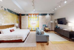 a bedroom with a king sized bed and a tv at 506 Lofts in Nashville