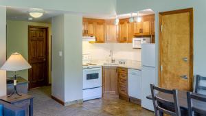 a kitchen with white appliances and wooden cabinets at Cahilty #429 home in Sun Peaks