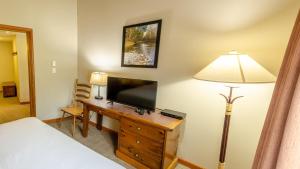 a bedroom with a television and a desk with a lamp at Cahilty #429 home in Sun Peaks