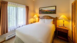 a bedroom with a large white bed and a window at Cahilty #429 home in Sun Peaks