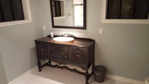 a bathroom with a sink and a mirror at Clinker Cottage Garden Apartment - Free Breakfast! in Albany +7 photos