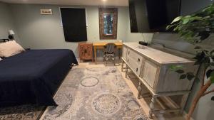 a bedroom with a bed and a dresser and a desk at Clinker Cottage Garden Apartment - Free Breakfast! in Albany