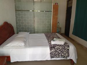 a bedroom with a bed with a towel on it at CASA HOTEL EL PRADo in Mesetas