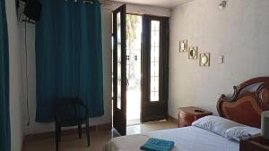 a bedroom with a bed and a door to a window at CASA HOTEL EL PRADo in Mesetas