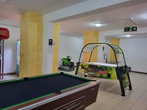 a room with a pool table and a simulator at Topaz Hotel in St. Paul's Bay