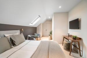 a bedroom with a bed and a desk and a tv at De Kompanie in Alken