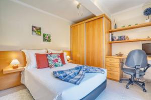 a bedroom with a bed and a desk and a chair at Vilamar 2 - Madeira Inn Group in Calheta