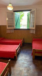 a room with three beds and a window at Hotel San Carlos in Mar del Plata