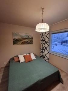 a bedroom with a green bed and a window at Guesthouse Sahanpera in Rovaniemi