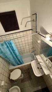 a bathroom with a toilet and a bath tub at Hotel San Carlos in Mar del Plata +26 photos