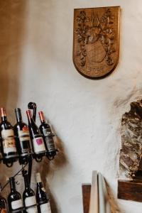 a bunch of wine bottles on a wall with a clock at Auberge Aal Veinen in Vianden