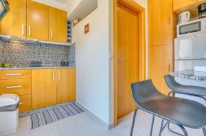 a kitchen with wooden cabinets and a table and chairs at Vilamar 2 - Madeira Inn Group in Calheta