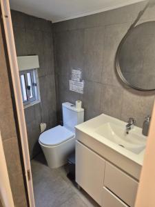 a bathroom with a toilet and a sink and a mirror at T1 Amadora in Amadora