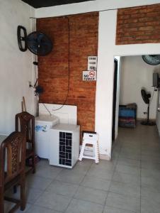 a room with a brick wall and a stool at Trotamundo in Los Polvorines