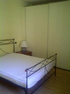 1 dormitorio con 1 cama y 1 mesa con lámpara en Casa Alberto, en Lucca