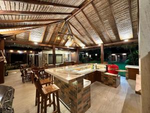 a kitchen with a large island with chairs and a table at Casa por Temporadas in Santa Cruz de la Sierra