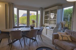 a living room with a table and chairs and a couch at Vakantiewoning Hornzicht in Anjum