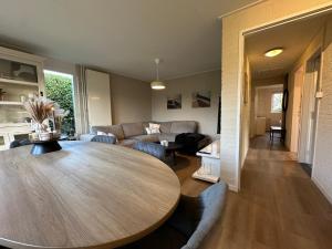 a living room with a wooden table and a couch at Vakantiewoning Hornzicht in Anjum